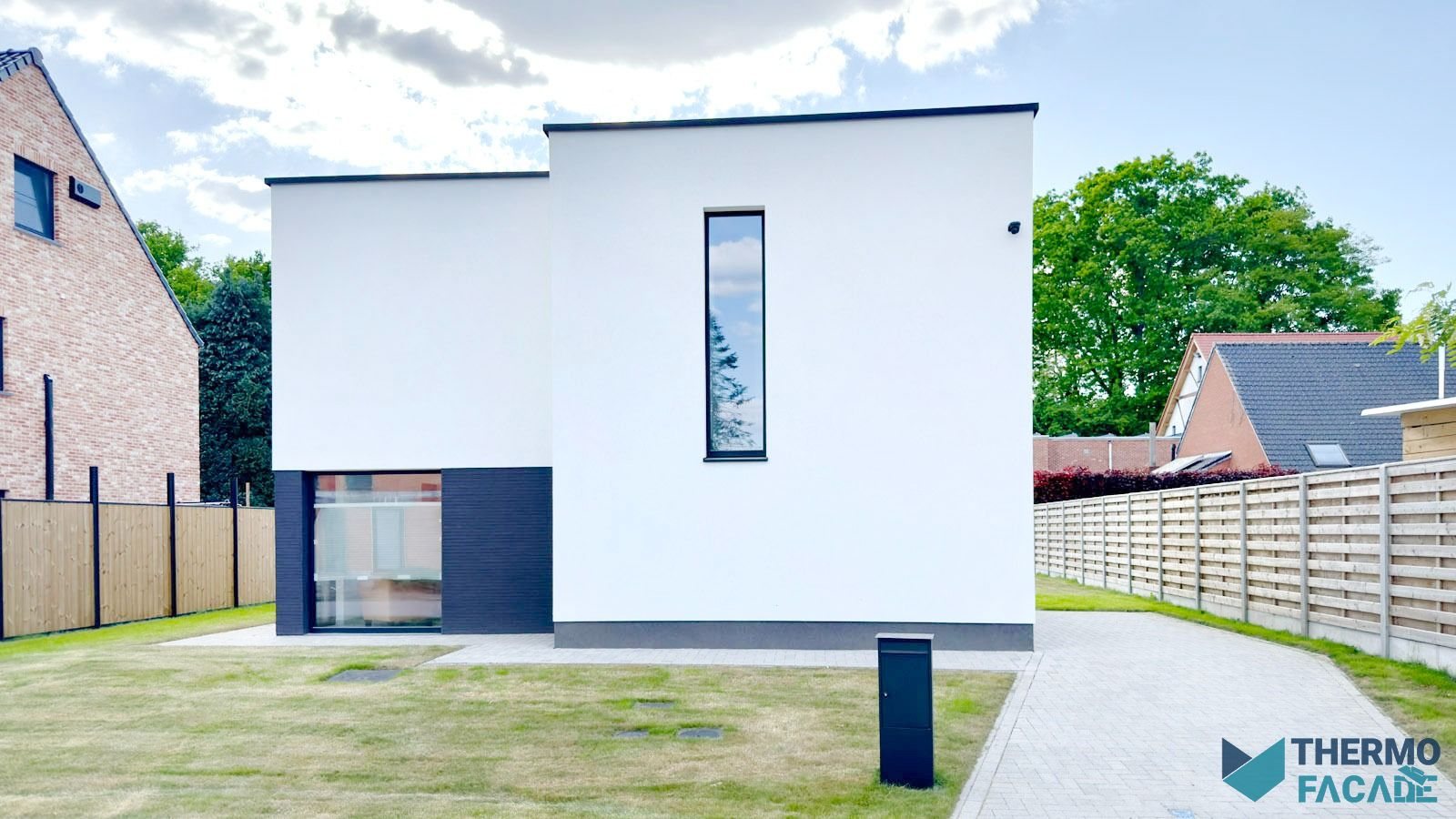 Wit gepleisterde woning met donkere sokkel en tuin